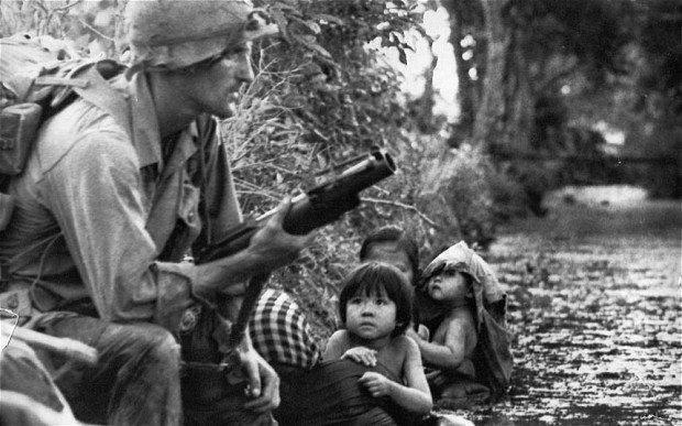 Um soldado dos EUA protege uma familia vietnamita do Sul.