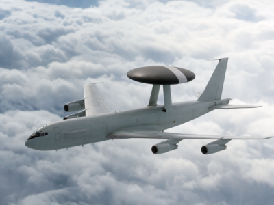 Avião AWACS em voo com radar circular sobre a fuselagem acima das nuvens