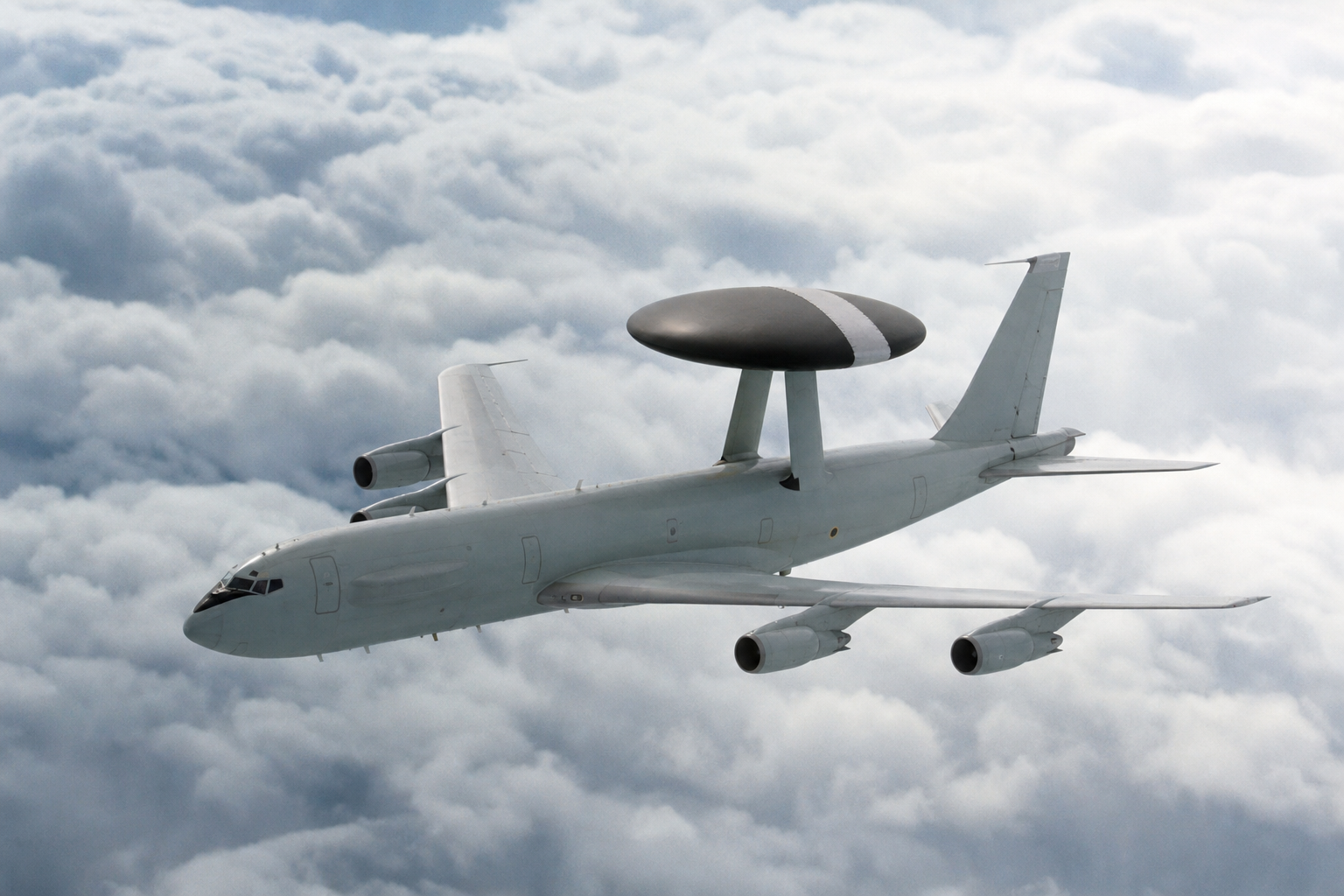 Avião AWACS em voo com radar circular sobre a fuselagem acima das nuvens
