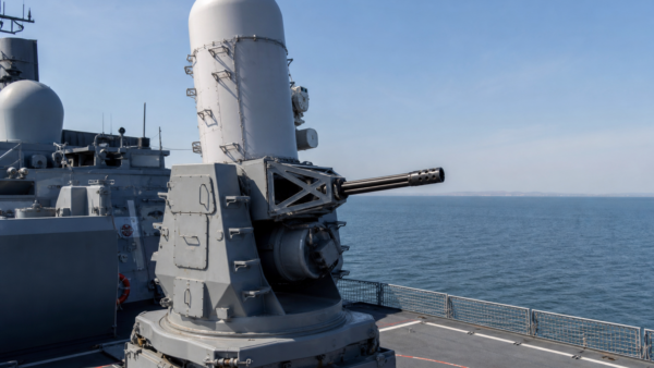 Sistema CIWS Phalanx instalado no convés de um navio militar moderno em mar calmo.