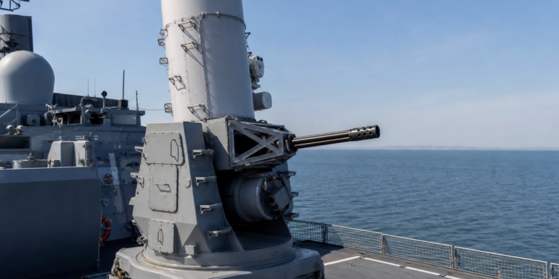 Sistema CIWS Phalanx instalado no convés de um navio militar moderno em mar calmo.