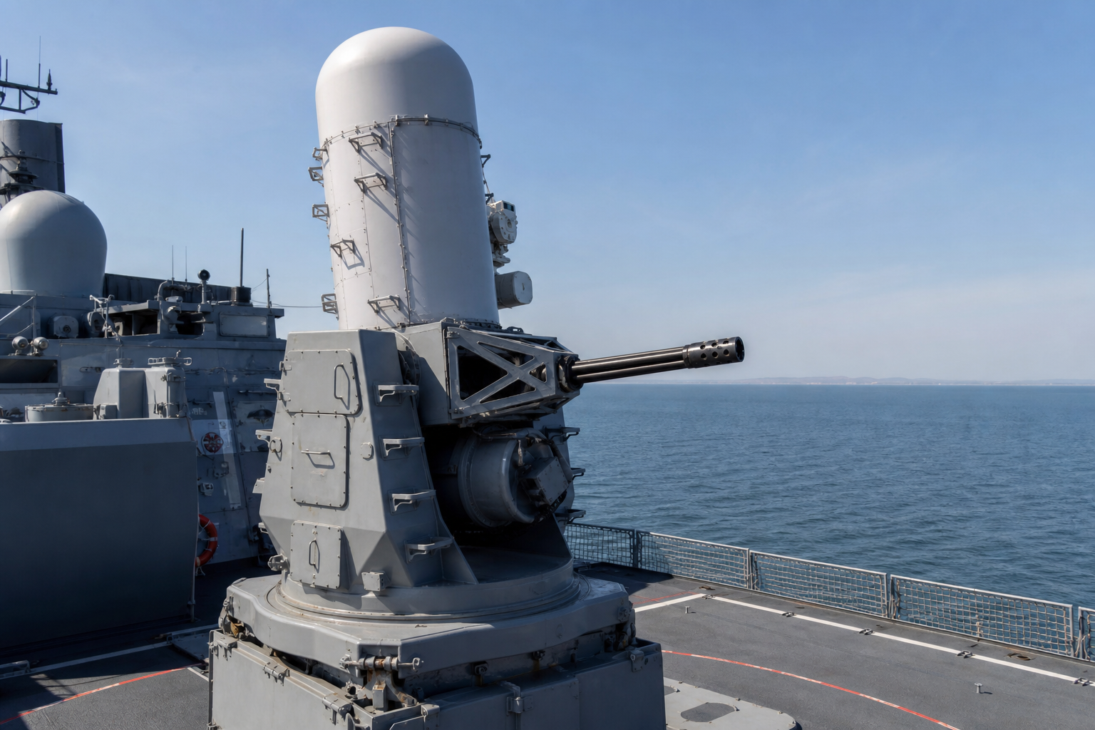 Sistema CIWS Phalanx instalado no convés de um navio militar moderno em mar calmo.