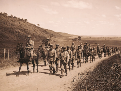 Representação histórica de soldados da Coluna Prestes marchando por estrada rural brasileira nos anos 1920