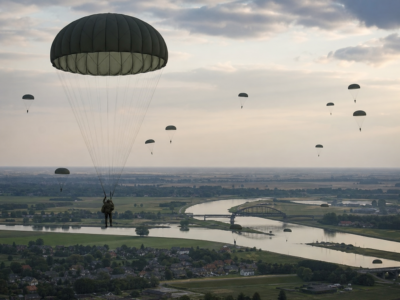 Paraquedistas aliados descendo sobre campos e pontes nos Países Baixos durante a Operação Market Garden