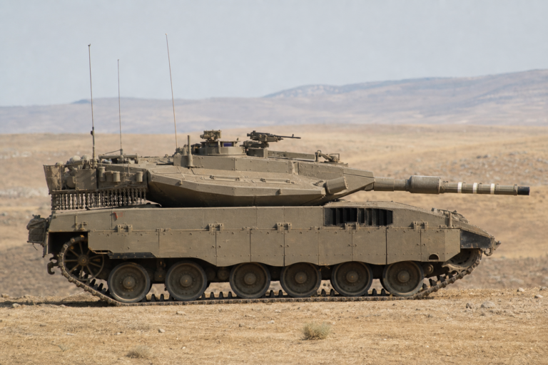 Tanque Merkava israelense visto de perfil em terreno árido durante exercício militar sem combate