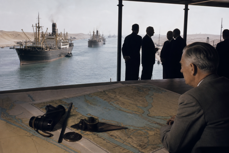 Representação educativa do Canal de Suez nos anos 1950 com navios mercantes e mapas diplomáticos.